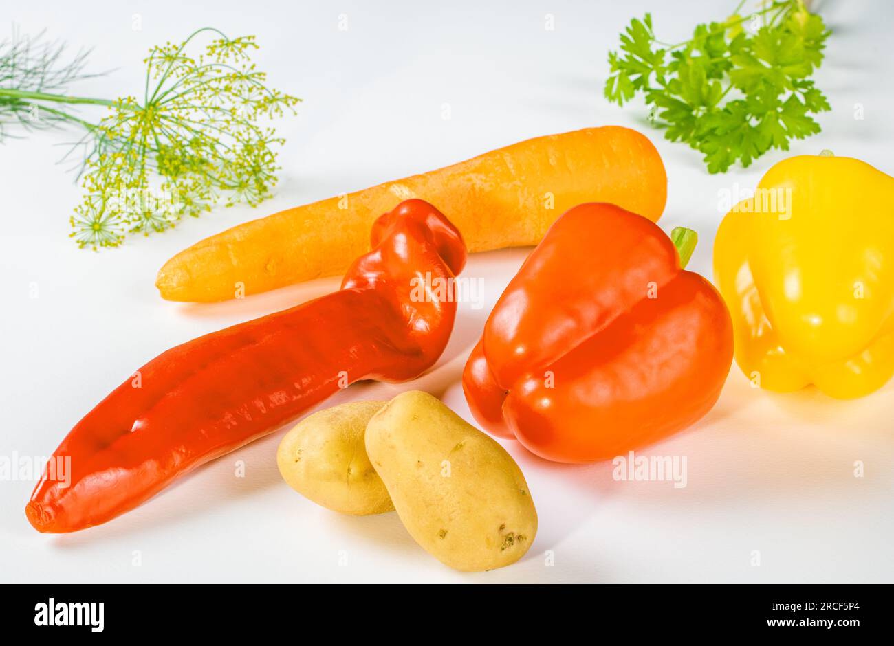 Gemischtes frisches Gemüse - Paprika, Karotten, Kartoffeln und Gemüse auf weißem Hintergrund. Stockfoto