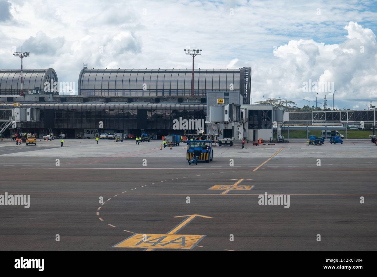 Medellin, Antioquia, Kolumbien - 17. Mai 2021: Mehrere Arbeiter in fluoreszierenden gelben Hemden und Blue Truck Cruising in der Airport Airway Stockfoto