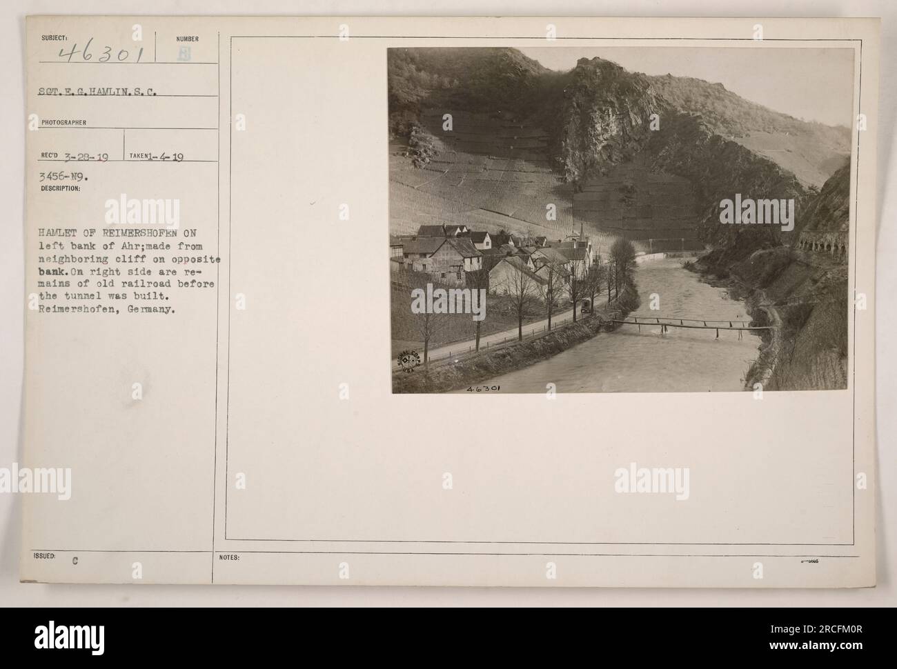 Das Dorf Reimershofen am linken Ufer von Ahr, von den benachbarten Klippen auf der gegenüberliegenden Uferseite aus gesehen. Überreste der alten Eisenbahn sind vor dem Tunnelbau auf der rechten Seite sichtbar. Befindet sich in Reimershofen, Deutschland. Foto aufgenommen am 28. März 1919 von S.E.G. Havlin, Fotograf für Sumber Reco. Bildnummer: AUFGENOMMEN-419 3456-19. Stockfoto