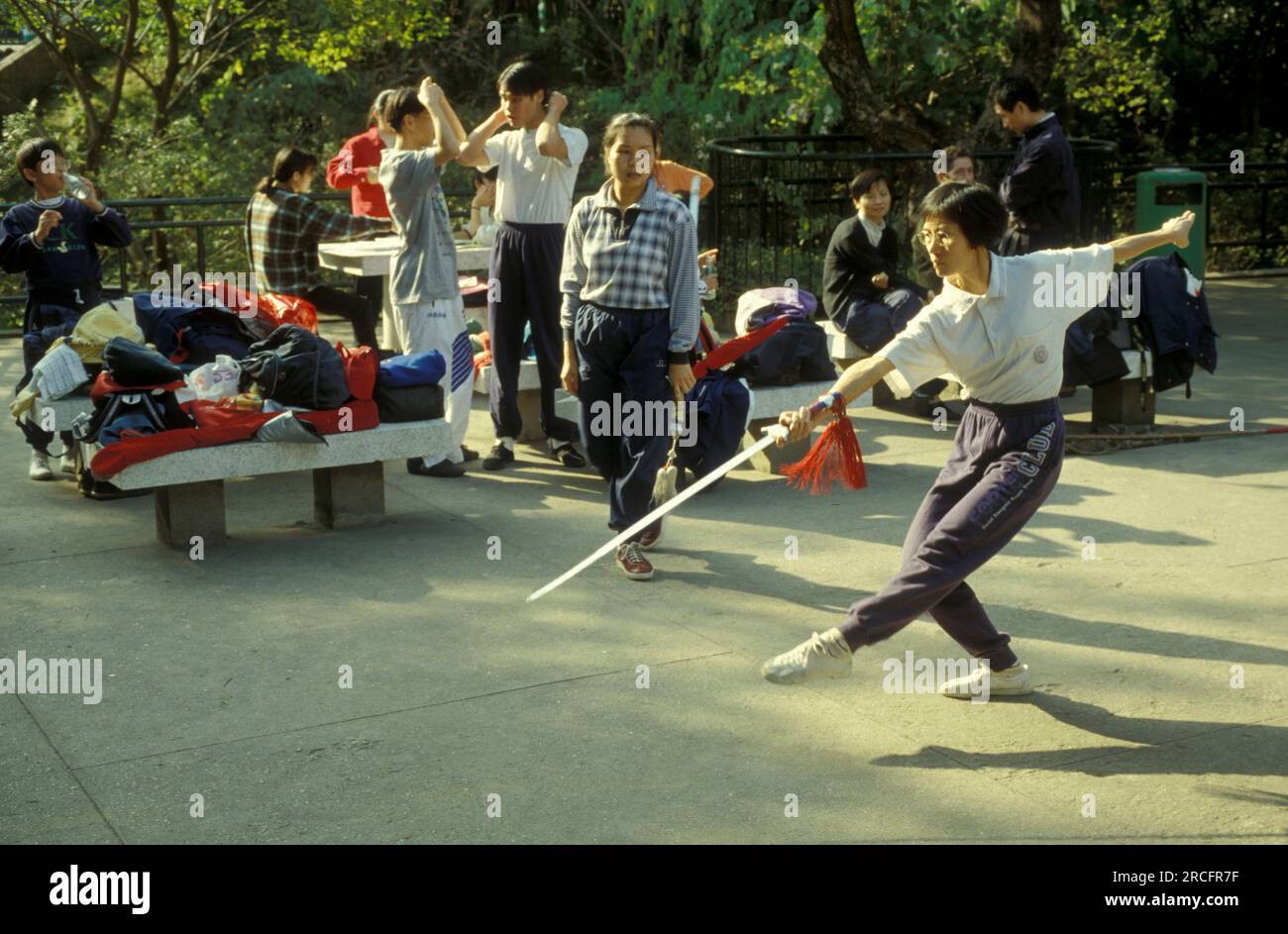 Menschen trainieren und Tai Chi in einem Park in Zentral-Hongkong in der Stadt Hongkong in Hongkong. China, Hongkong, Mai 1997 Stockfoto