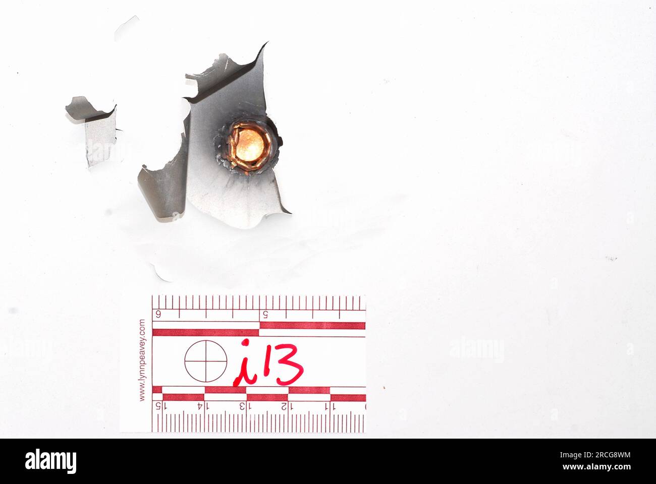 Die Pistolenkugel steckt in einer Türverkleidung fest Stockfoto