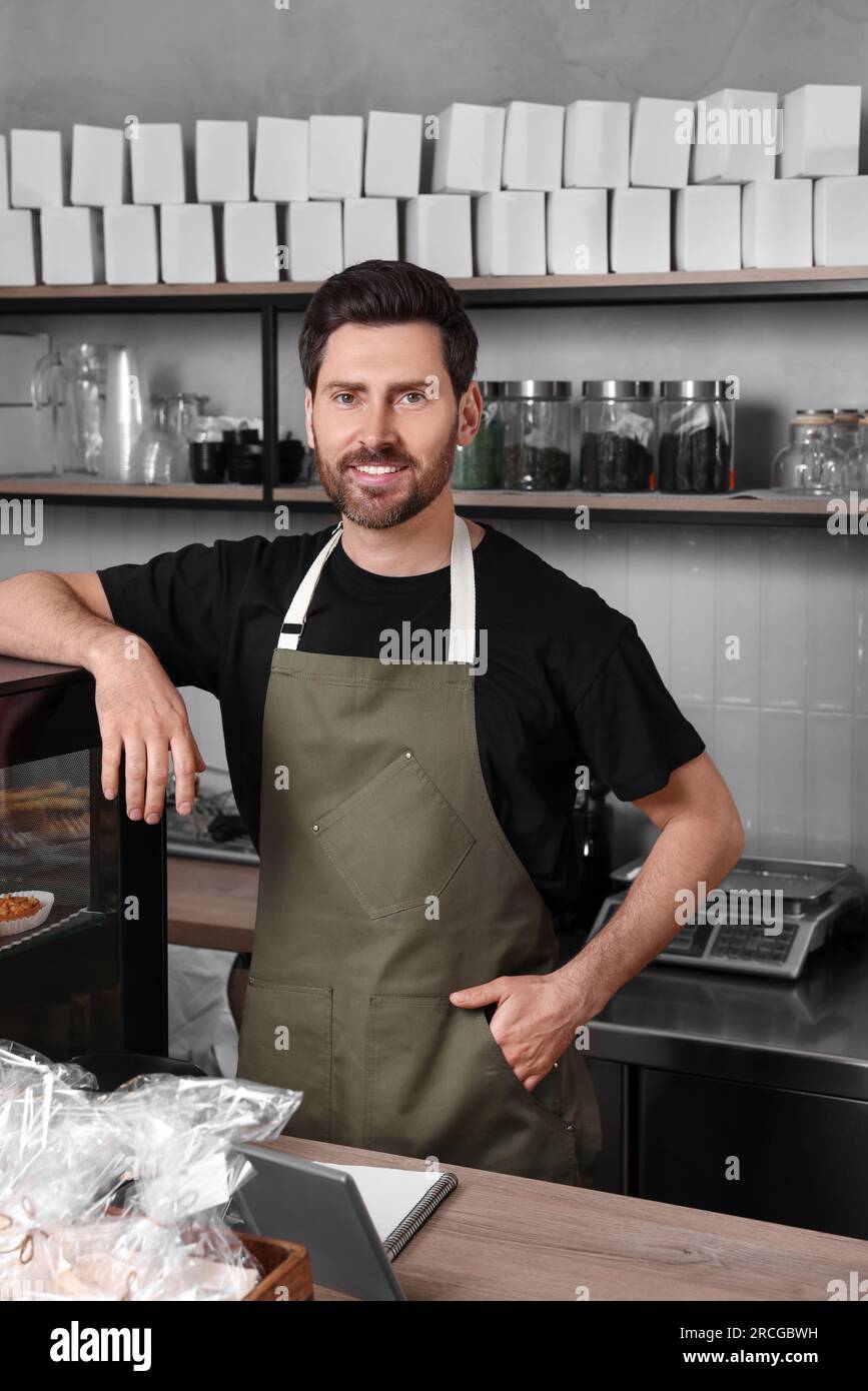 Portrait eines glücklichen Verkäufers an der Kasse in einer Bäckerei Stockfoto