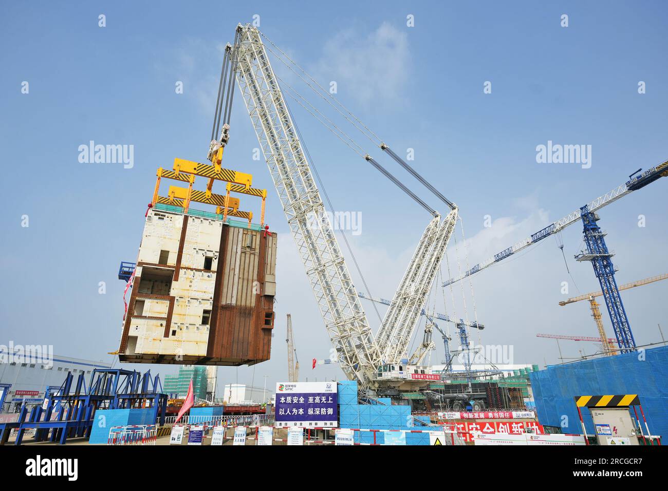 YANTAI, CHINA - 14. JULI 2023 - Ein großer Kran hebt das CA20-Modul in die Atominsel von Block 4 im Kernkraftwerk Shandong Haiyang in Y Stockfoto