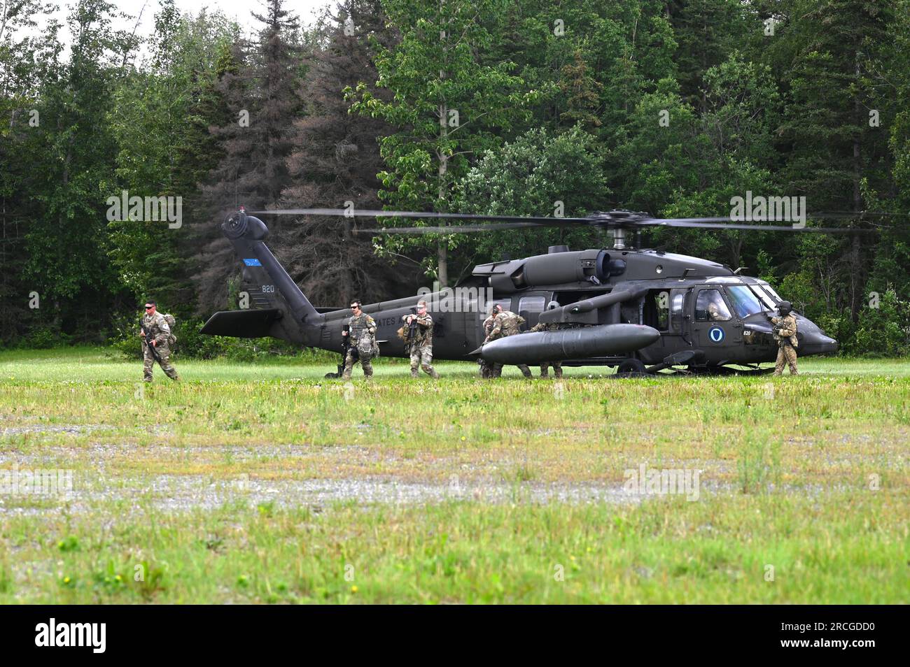 USA Soldaten, die am besten Krieger-Wettbewerb (BWC) der Army National Guard (ARNG) teilnehmen, verlassen einen UH-60L Black Hawk Helikopter, der Einem Unternehmen zugewiesen ist, 1. Bataillon, 168. Luftfahrtregiment, Alaska Nationalgarde auf der gemeinsamen Basis Elmendorf-Richardson, Alaska 12. Juli 2023. Die ARNG BWC testet die Anpassungsfähigkeit und Letalität unserer Streitkräfte, da unsere Bürgersoldaten der Nationalgarde weiterhin bereit und widerstandsfähig sind, die Herausforderungen der Nation zu bewältigen. (USA Air National Guard (Foto) von Master Sgt. David Eichaker) Stockfoto