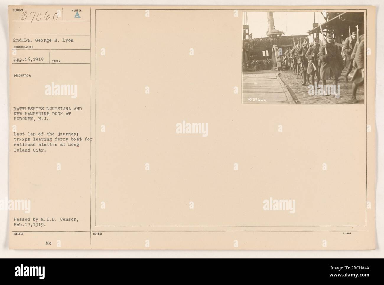 Ein Foto, aufgenommen von 2. Lieutenant George H. Lyon im Februar 1919. Das Bild zeigt die Schlachtschiffe Louisiana und New Hampshire, die in Hoboken, New Jersey, angedockt sind. Es zeigt Truppen, die von einer Fähre aussteigen und sich auf den Weg zu einem Bahnhof in Long Island City machen. Das Foto wurde vom M.I.D. genehmigt Zensor am 17. Februar 1919. Stockfoto