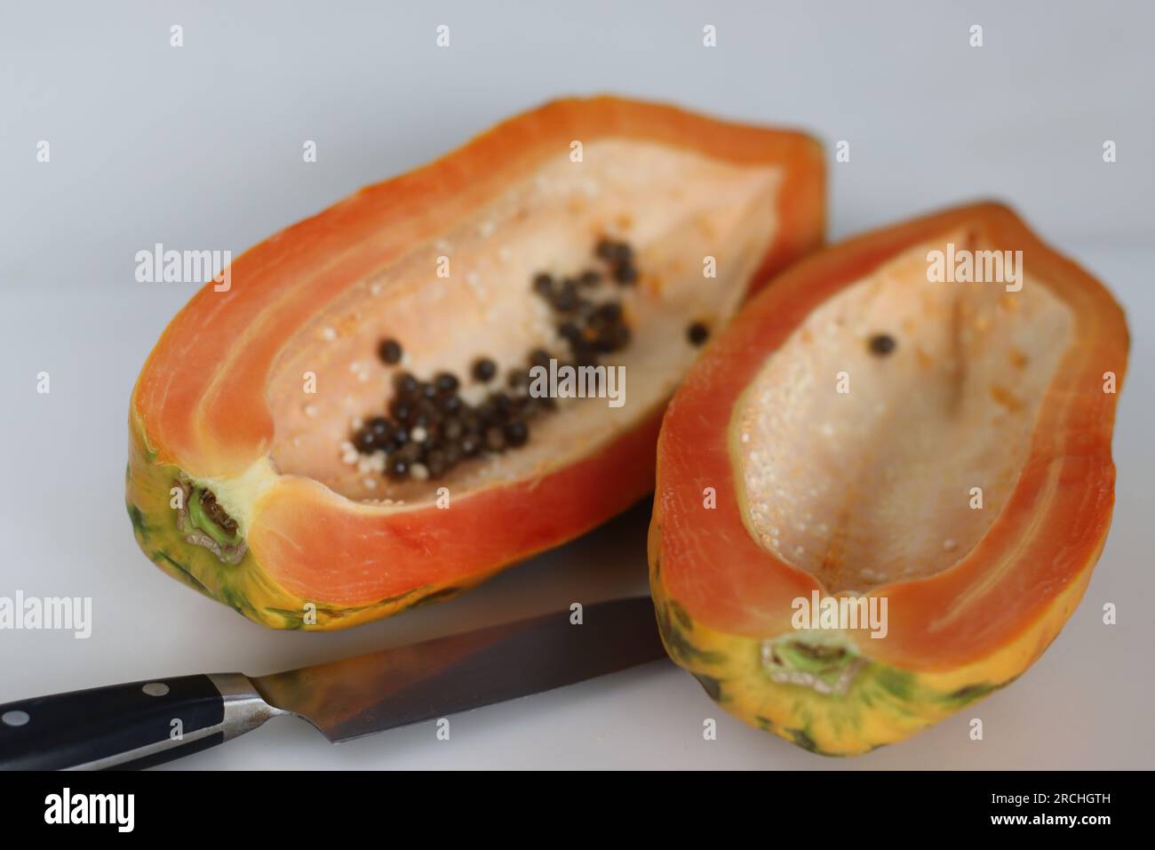 Reife und verzehrfertige Papayaschneiden. Lange Scheiben reifer Papaya mit weniger Samen im Inneren. Sie hat orangisch-gelbe Haut und ist weich zu berühren. S Stockfoto