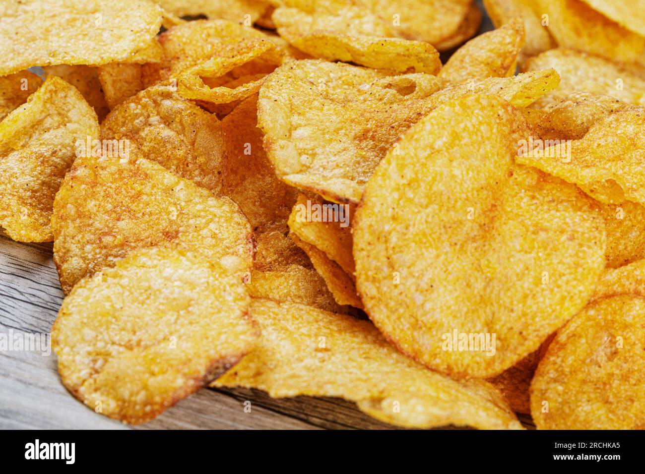 Köstliche Kartoffelchips mit Barbecue-Geschmack isoliert auf Holzhintergrund mit Kopierbereich Stockfoto