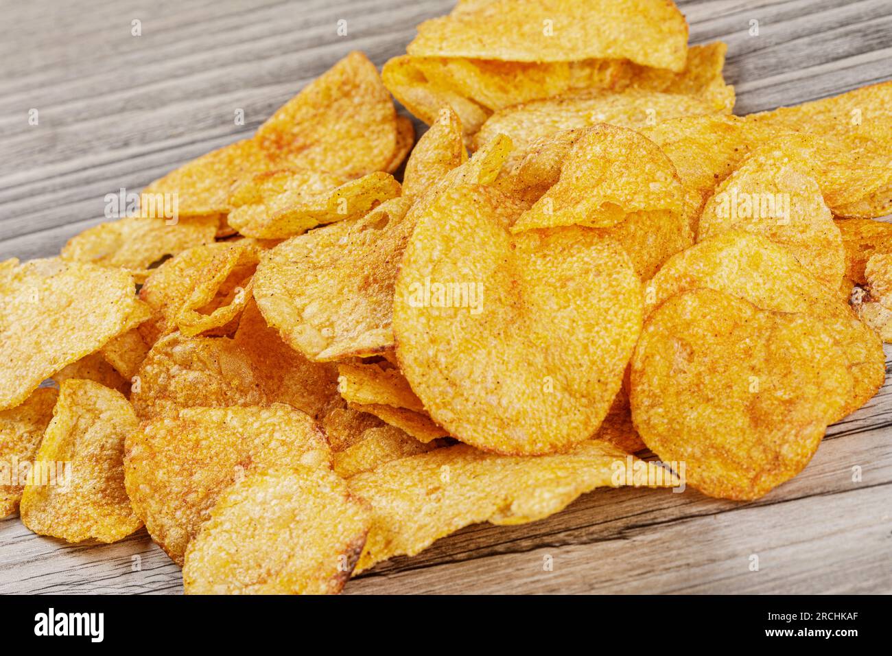 Köstliche Kartoffelchips mit Barbecue-Geschmack isoliert auf Holzhintergrund mit Kopierbereich Stockfoto