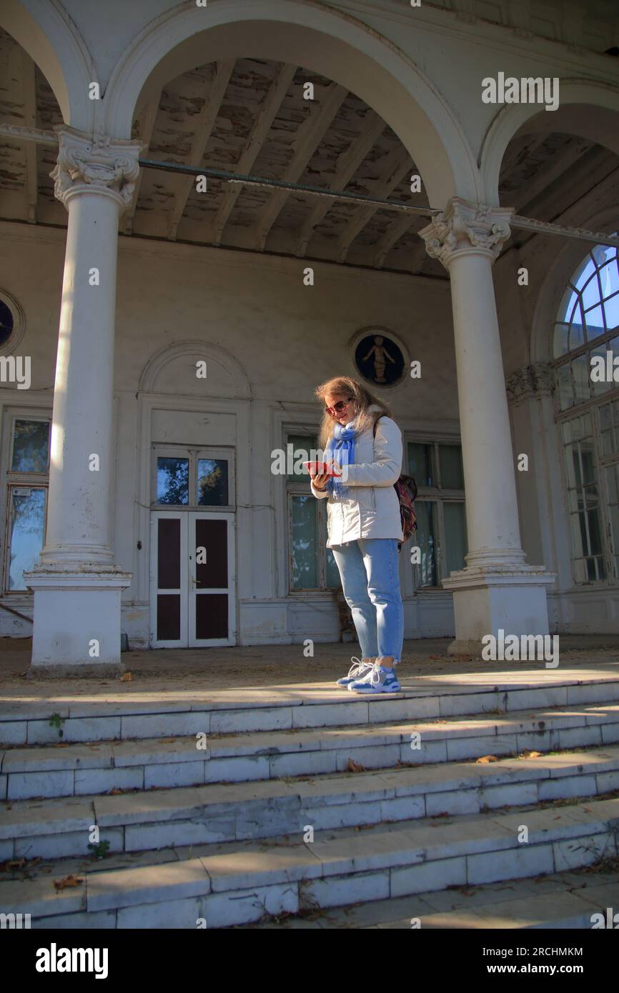 Das Foto wurde in Odessa gemacht. Eine junge Touristin auf der Treppe eines alten Anwesens am French Boulevard im ehemaligen Wohnheim-Gebäude von Th Stockfoto