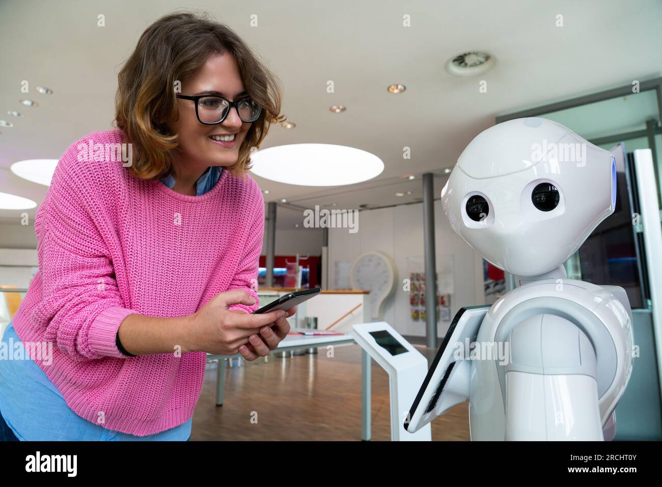 Eine Frau kommuniziert mit einem Roboterberater. Stockfoto