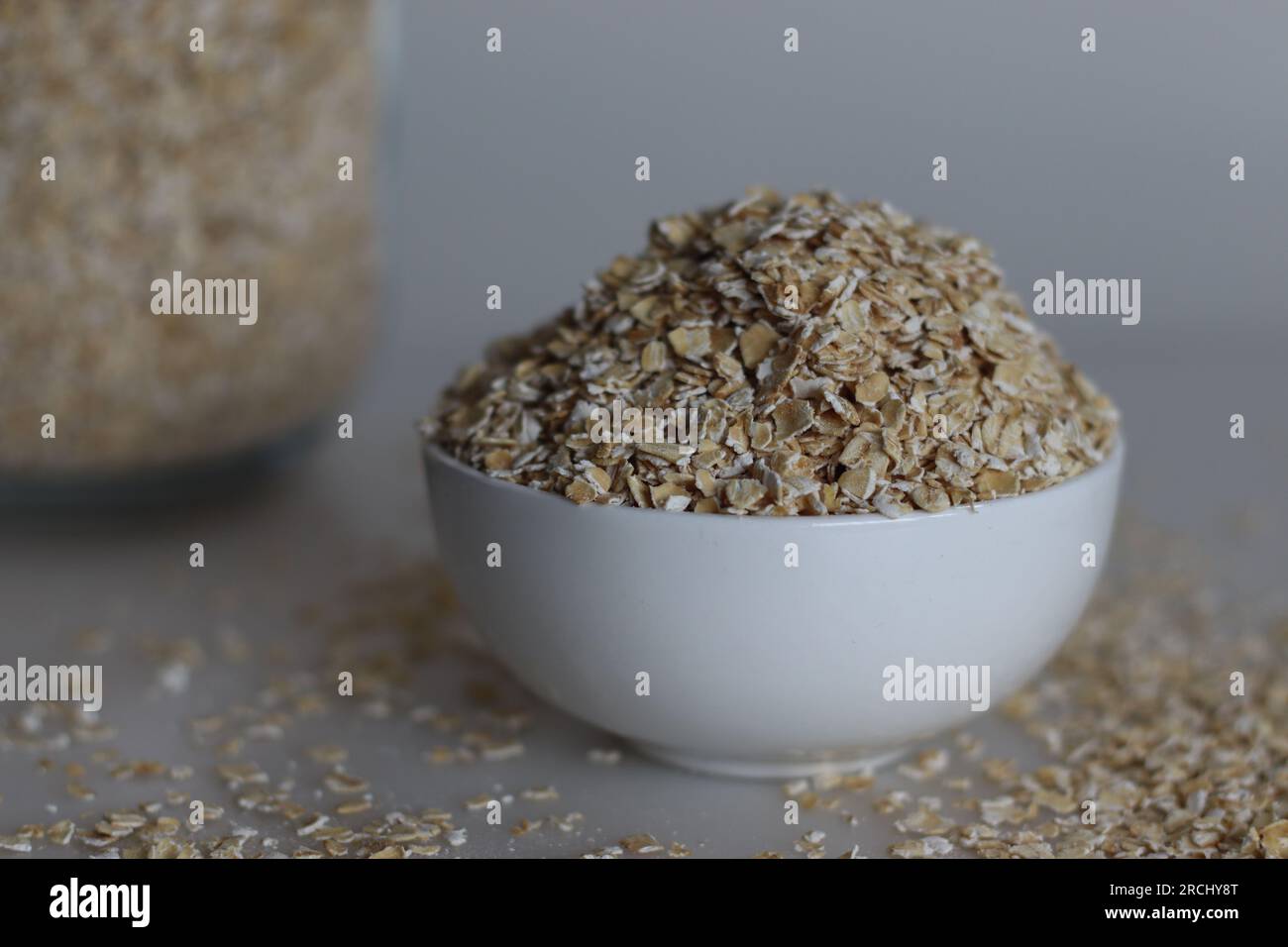 Eine Schüssel mit Hafer zum schnellen Kochen oder Hafer zum schnellen Kochen. Es handelt sich um Hafergerollt, der weiterverarbeitet wird, um die Garzeit zu verkürzen. Sie haben eine milde fl Stockfoto