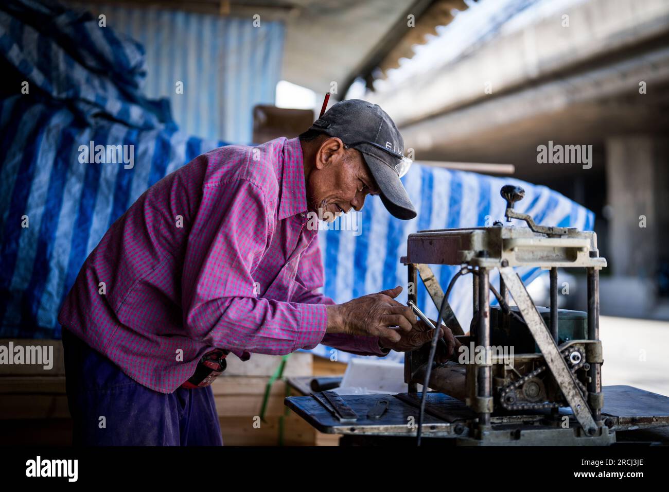 Bangkok, Thailand. 15. Juli 2023. Ein Mann, der an einer Maschine in der Nähe von Khlong Toey arbeitet. Kredit: SOPA Images Limited/Alamy Live News Stockfoto
