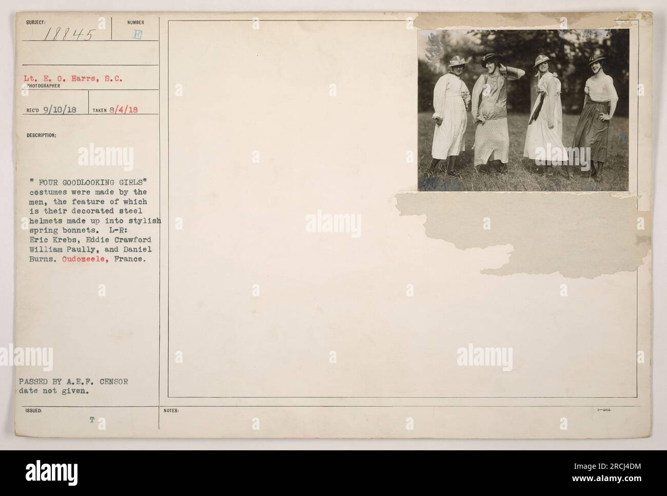 Vier Soldaten in Oudozeele, Frankreich, posieren in Outfits mit dekorierten Stahlhelmen als stilvolle Federhauben. Die Kostüme wurden von den Männern selbst kreiert. Auf dem Foto von links nach rechts sind Eric Krebs, Eddie Crawford, William Paully und Daniel Burns zu sehen. Das Datum, an dem das Foto ausgestellt und vom A.E.P.-Zensor genehmigt wurde, wird nicht angegeben. (Fotograf) Rico. Aufgenommen am 4. August 1918. LT. E.O. Harrs, S.C. Foto Des Kriegsministeriums. Referenznummer: 18845. Stockfoto