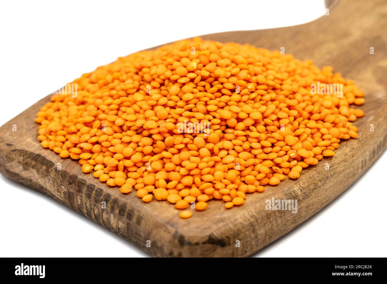 Rote Linsen auf weißem Hintergrund isoliert. Rohe rote Linsen auf Holzserviertafel. Schließen Stockfoto