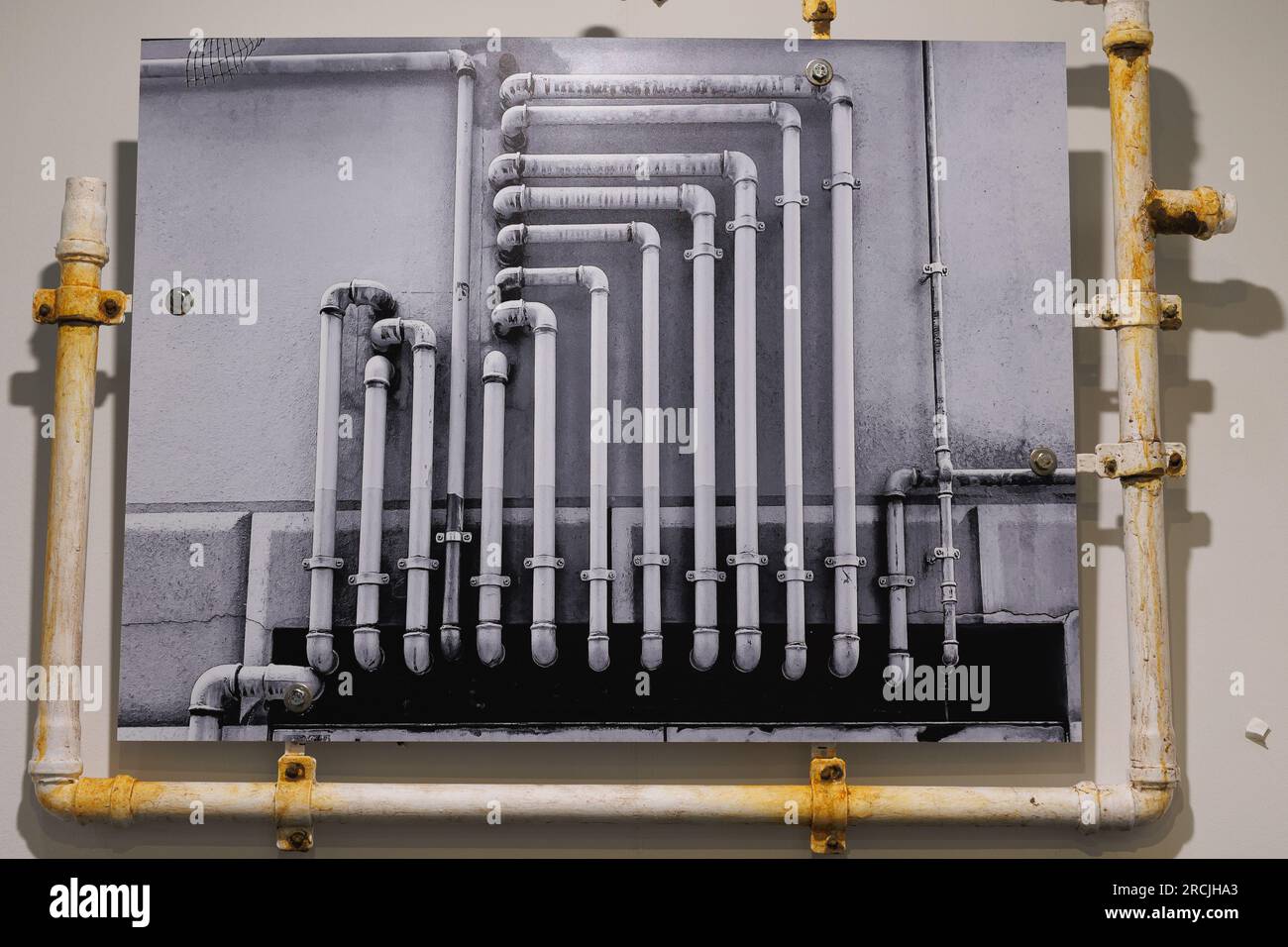 Künstlerische Darstellung einer echten Pipe, die ein Schwarzweißfoto mit Rohren umrahmt. Stockfoto
