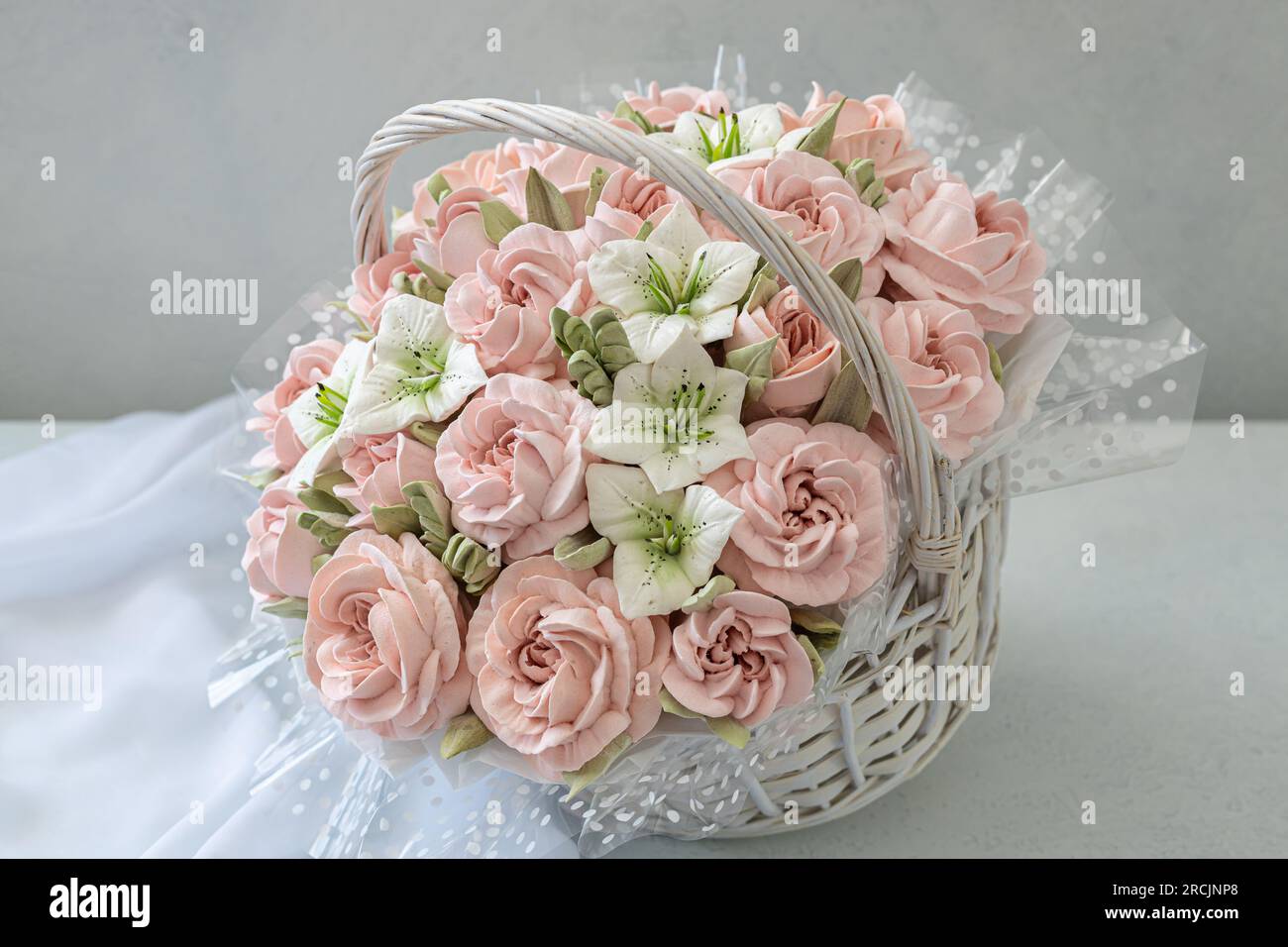 Zephyr-Blumenstrauß in einem Weidenkorb auf hellem Hintergrund Stockfoto