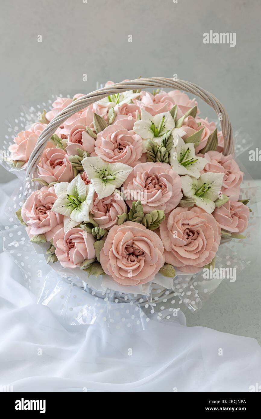 Zephyr-Blumenstrauß in einem Weidenkorb auf hellem Hintergrund Stockfoto