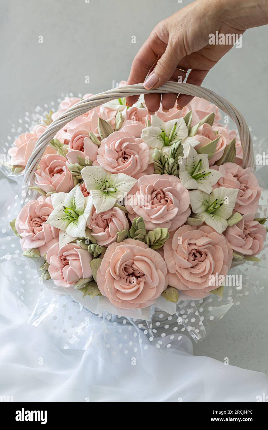 Zephyr-Blumenstrauß in einem Weidenkorb auf hellem Hintergrund Stockfoto