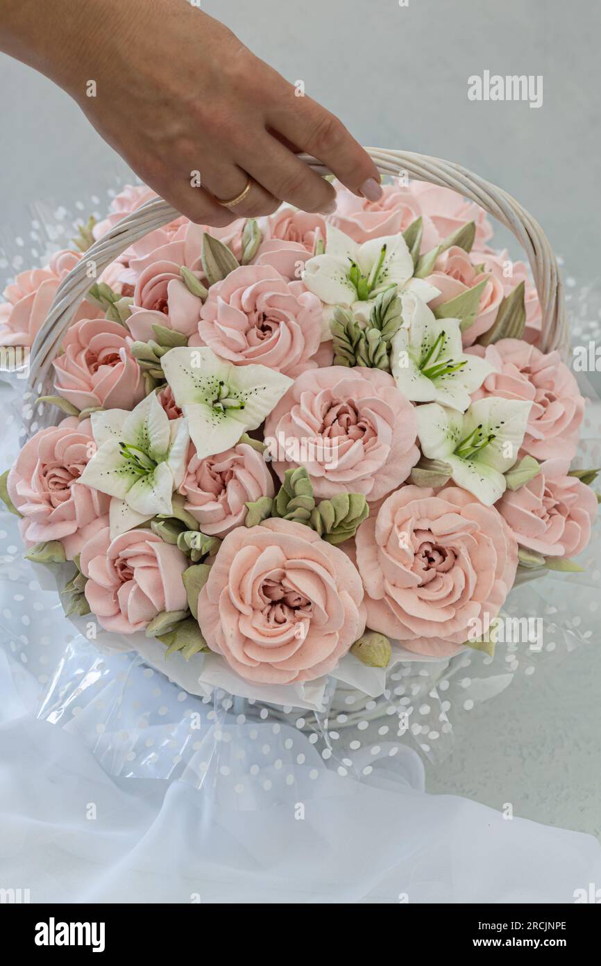 Zephyr-Blumenstrauß in einem Weidenkorb auf hellem Hintergrund Stockfoto