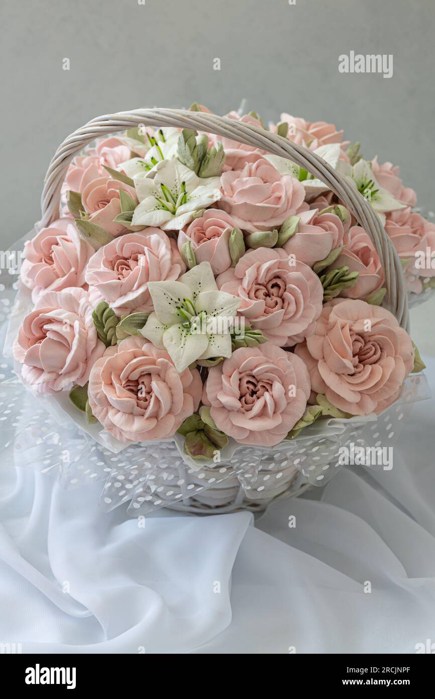 Zephyr-Blumenstrauß in einem Weidenkorb auf hellem Hintergrund Stockfoto