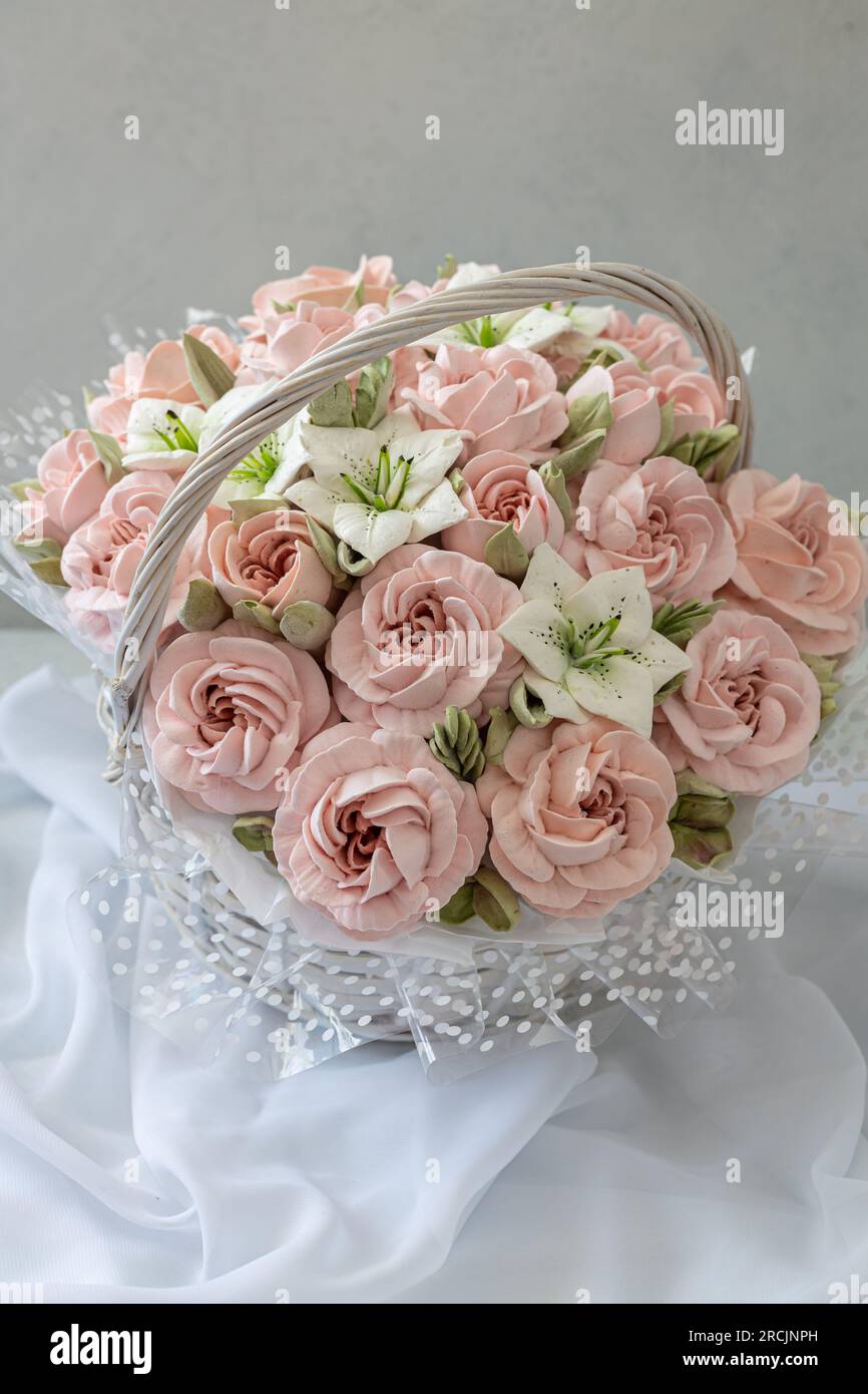 Zephyr-Blumenstrauß in einem Weidenkorb auf hellem Hintergrund Stockfoto