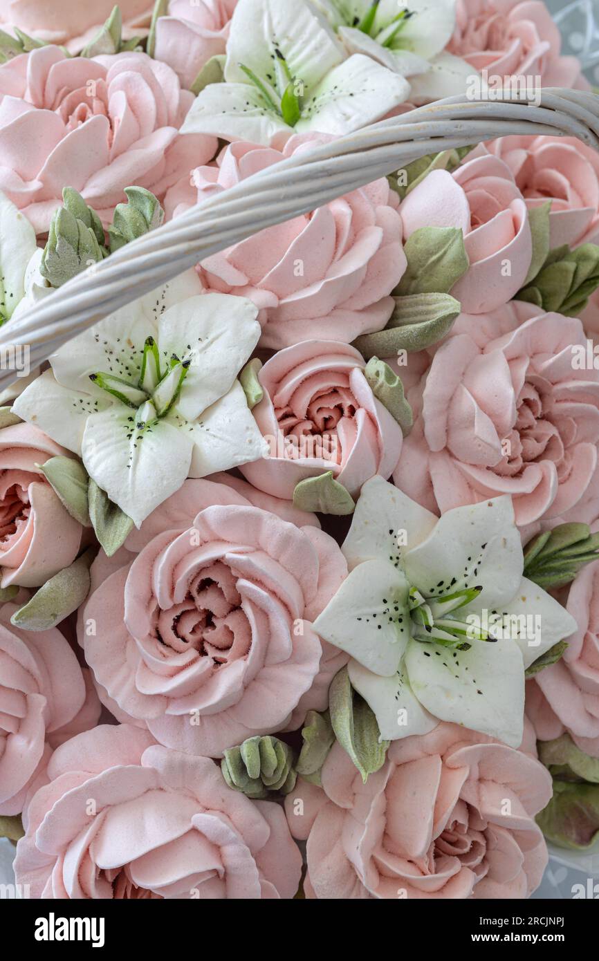 Zephyr-Blumenstrauß in einem Weidenkorb auf hellem Hintergrund Stockfoto