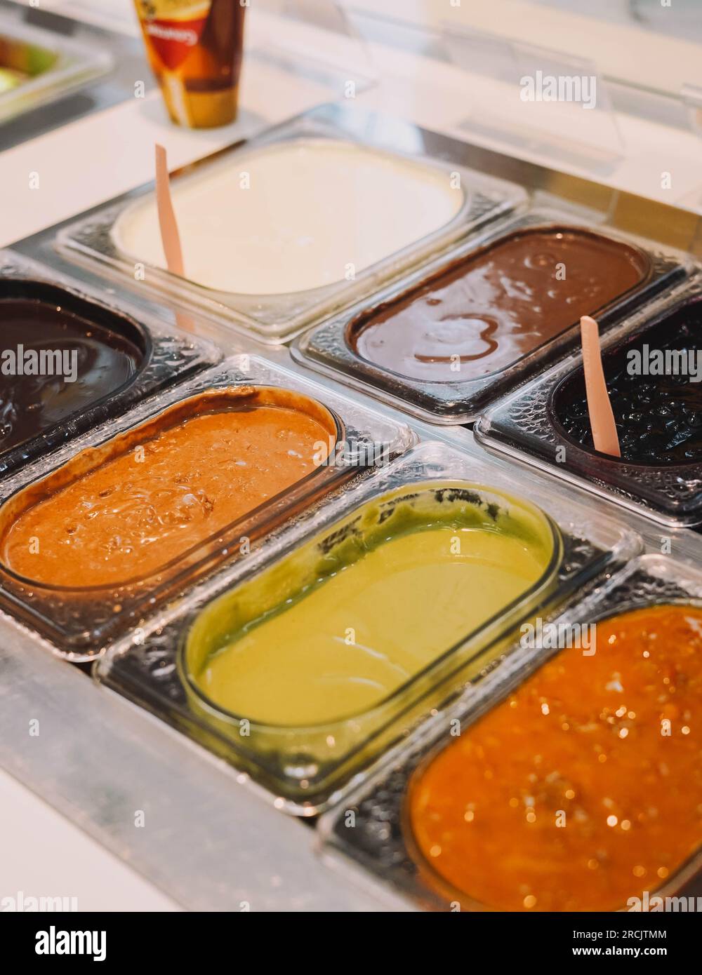 Süße Saucen verschiedener Geschmacksrichtungen als Topping auf Eis Stockfoto