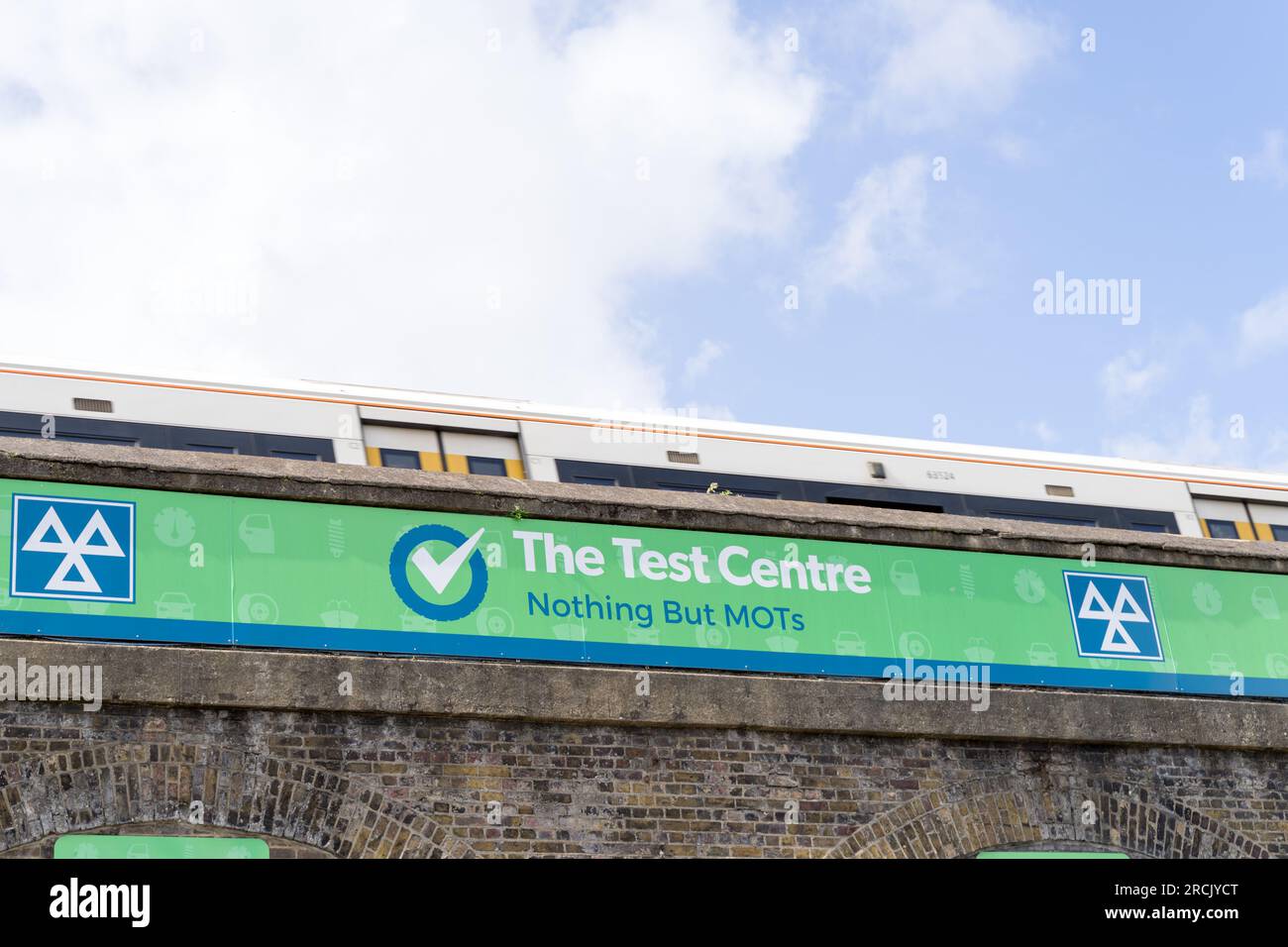 Der südöstliche Zug fährt über eine Brücke und zeigt das Logo des MOT-Testzentrums London UK an Stockfoto