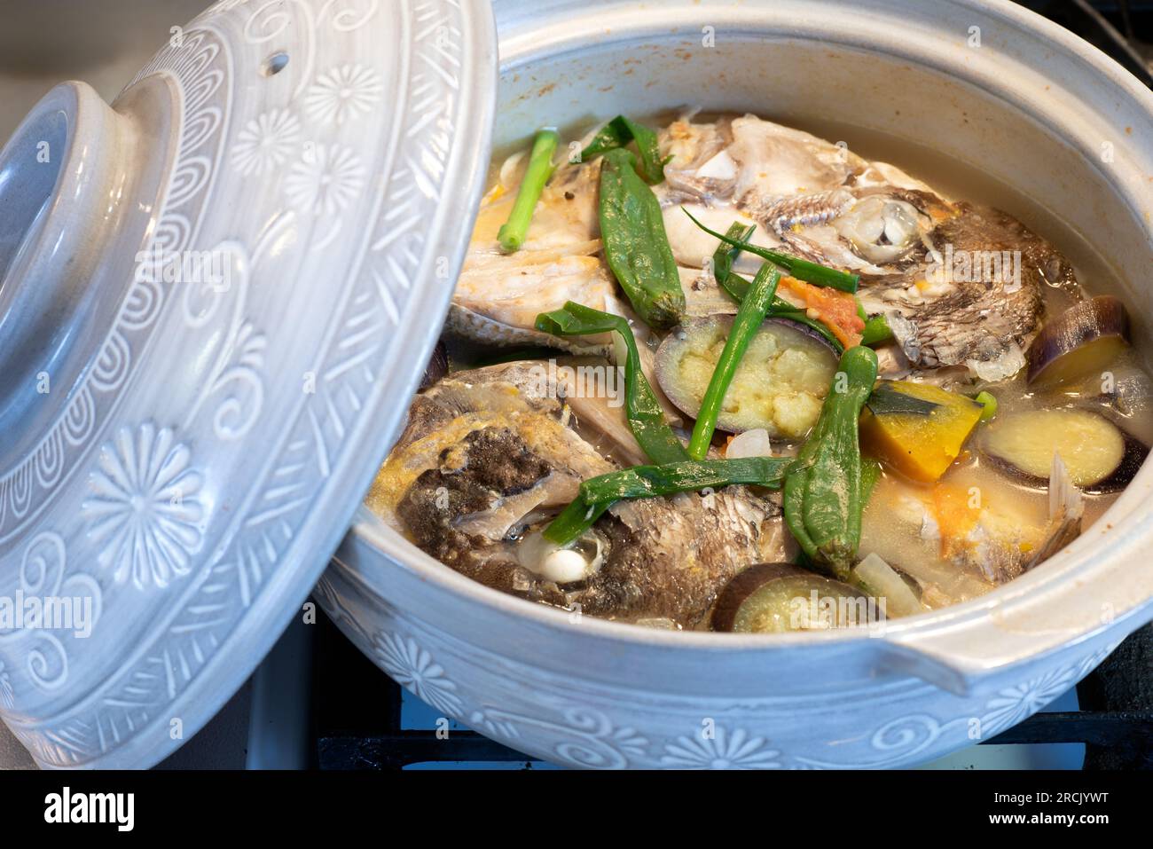 Fischköpfchen in einem Keramiktopf. Sinabawang ulo ng isda. Stockfoto