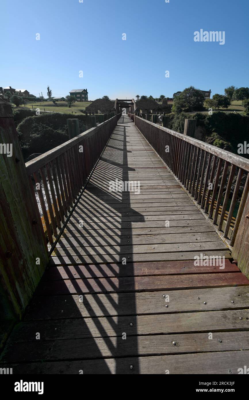 Holzbrücke mit Bögen und brauner Farbe, mit einem Aussichtspunkt am Ende über das Wasser der Ribadeo-Mündung. Stockfoto