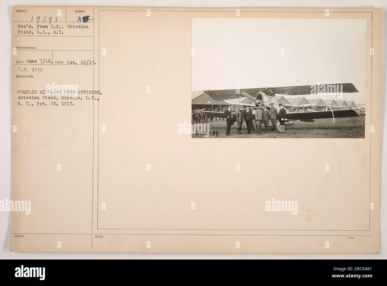 Dieses Foto zeigt ein Pomilio-Flugzeug zusammen mit Offizieren auf dem Flugplatz in Mineola, L.I. Es wurde am 22. Oktober 1917 aufgenommen und vom C.O., Aviation Field, L.I., N. Y. empfangen. Der Fotograf, der für dieses Bild verantwortlich ist, ist Sumber Recs. Dieses Foto ist als Subjekt 19593 klassifiziert. Stockfoto