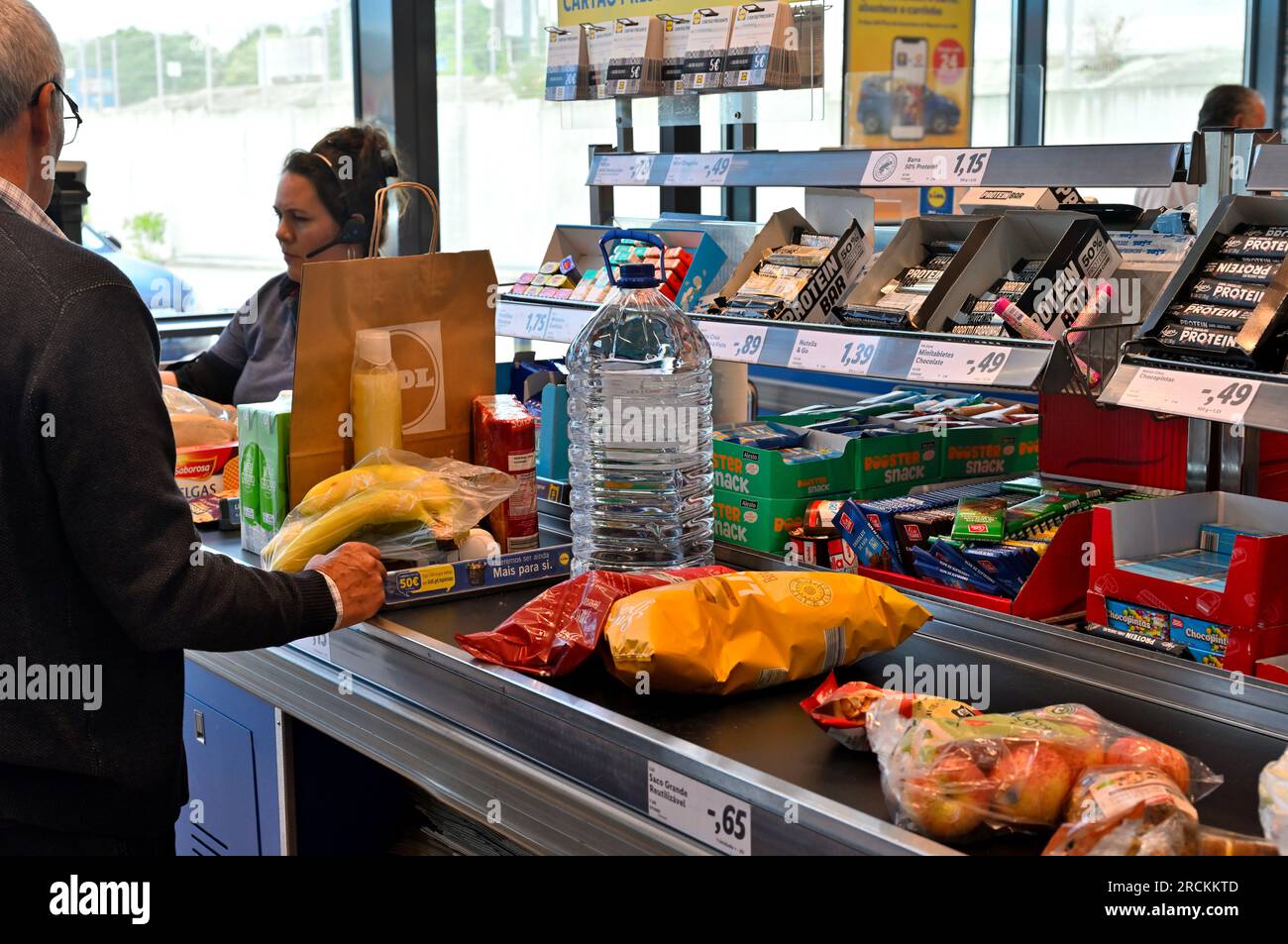 Kunde mit Essen auf Förderband bei der Kasse im Supermarkt Stockfoto