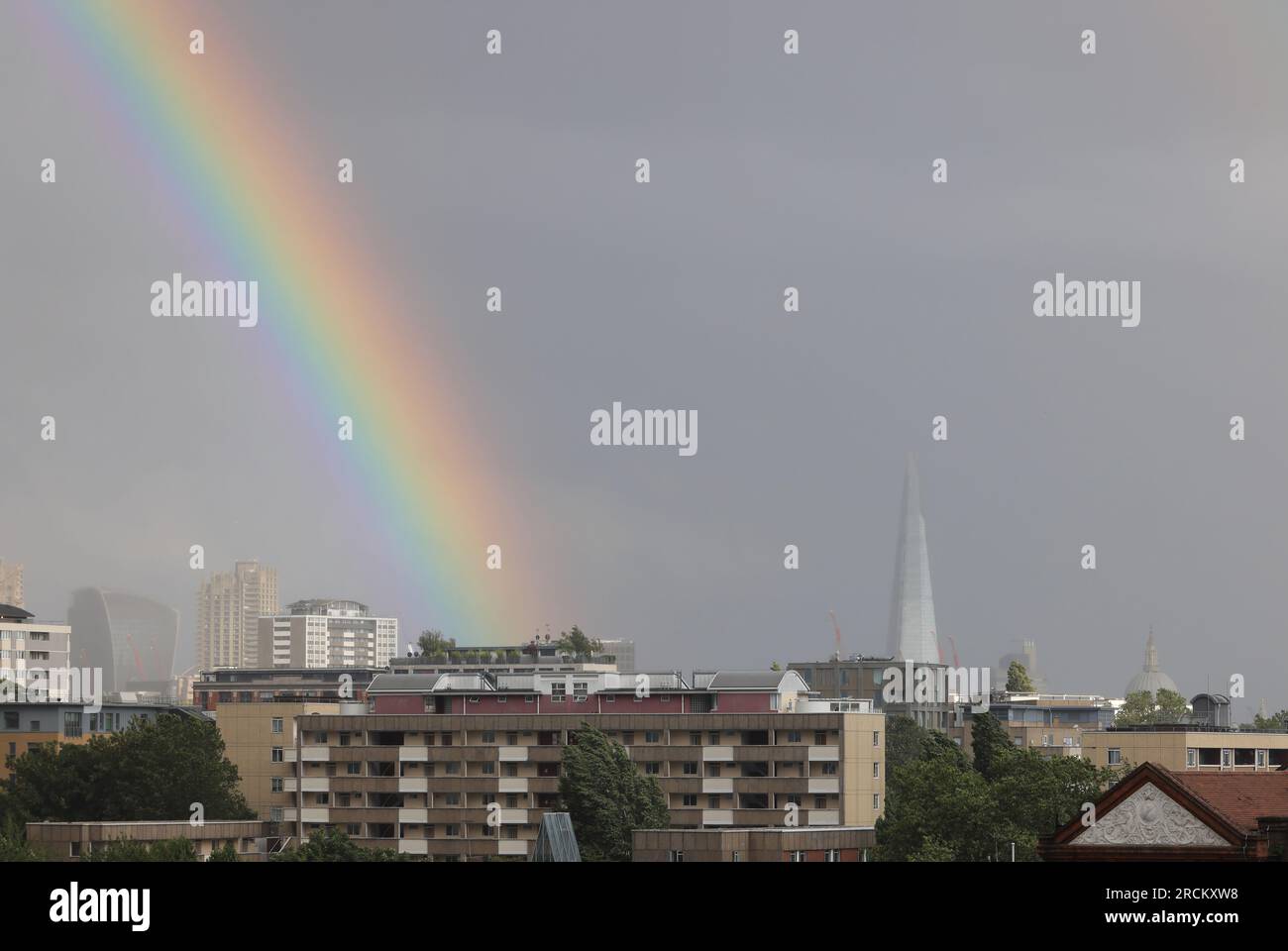 London, UK, 15. Juli 2023. Während Südeuropa von heißen Temperaturen heimgesucht wurde, gab das MET-Büro heute eine gelbe Wetterwarnung für London und den Südosten aus, aufgrund eines niedrigen Drucks. Es wurden starke Winde von bis zu 55 km/h erwartet, zusammen mit scharfen Schauern, die heute Abend zu diesem Regenbogen über der Stadt führten. Kredit : Monica Wells/Alamy Live News Stockfoto