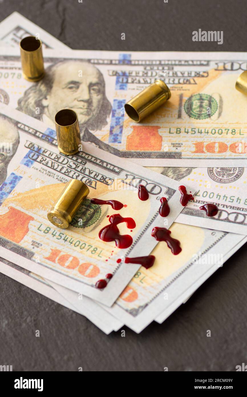 Spucke Blut auf Hundert-Dollar-Scheine und Feuerwaffenkassetten Verbrechen schmutziges Geld Konzept Stockfoto