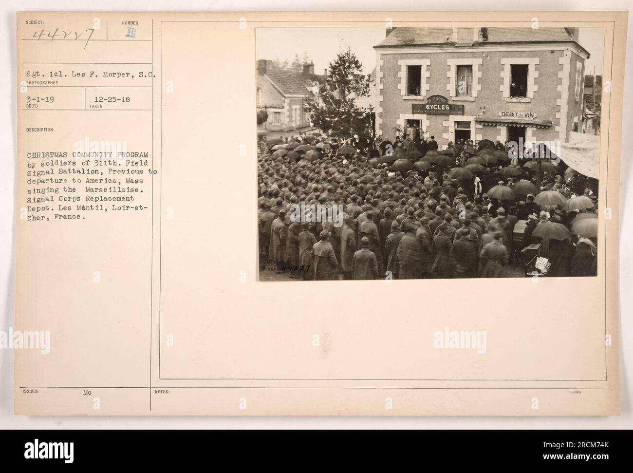 Soldaten des 311. Feldsignalbataillons nehmen vor ihrer Abreise nach Amerika an einem Weihnachtsprogramm Teil. Das Foto zeigt Sergeant Leo P. Morper, der eine Gruppe anführt, die die französische Nationalhymne La Marseillaise im Ersatzlager des Signalkorps in Les Mentil, Loir-et-Cher, Frankreich singt. Stockfoto