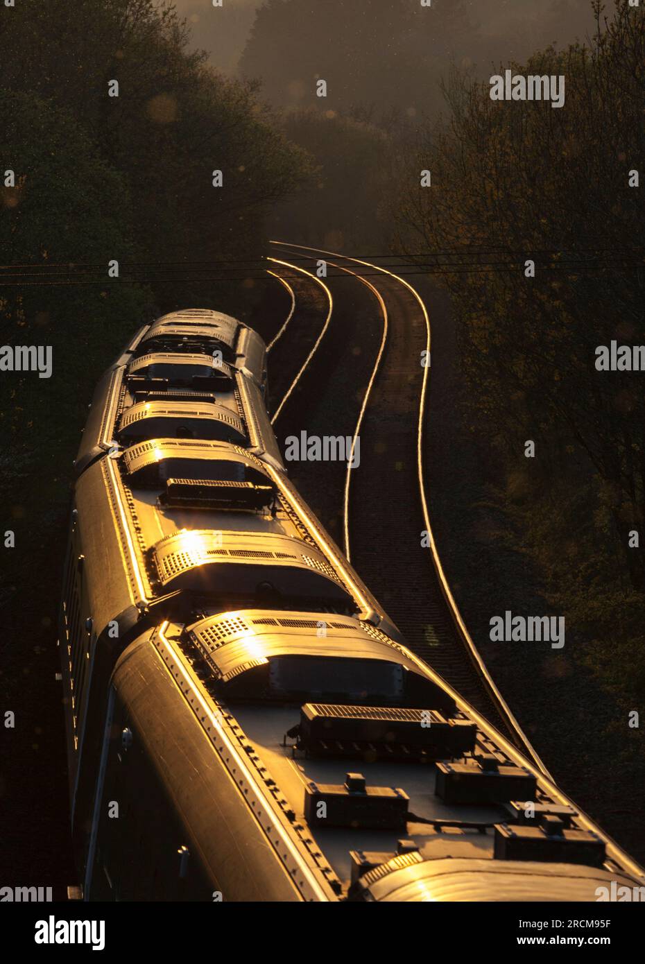 Die erste Great Western Railway Hitachi IET bi - der Moduszug fährt in den Sonnenuntergang auf der Hauptlinie von Süd-Wales bei Llangewydd, die sich um eine Kurve krümmt Stockfoto