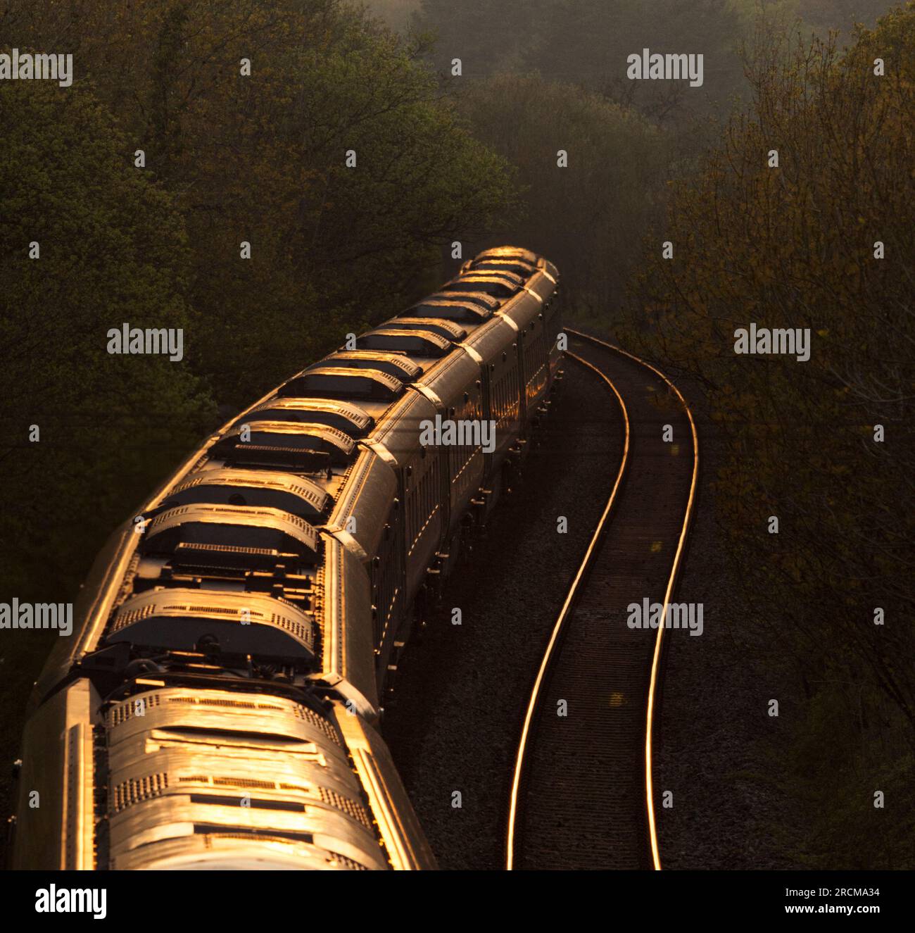 Die erste Great Western Railway Hitachi IET bi - der Moduszug fährt in den Sonnenuntergang auf der Hauptlinie von Süd-Wales bei Llangewydd, die sich um eine Kurve krümmt Stockfoto