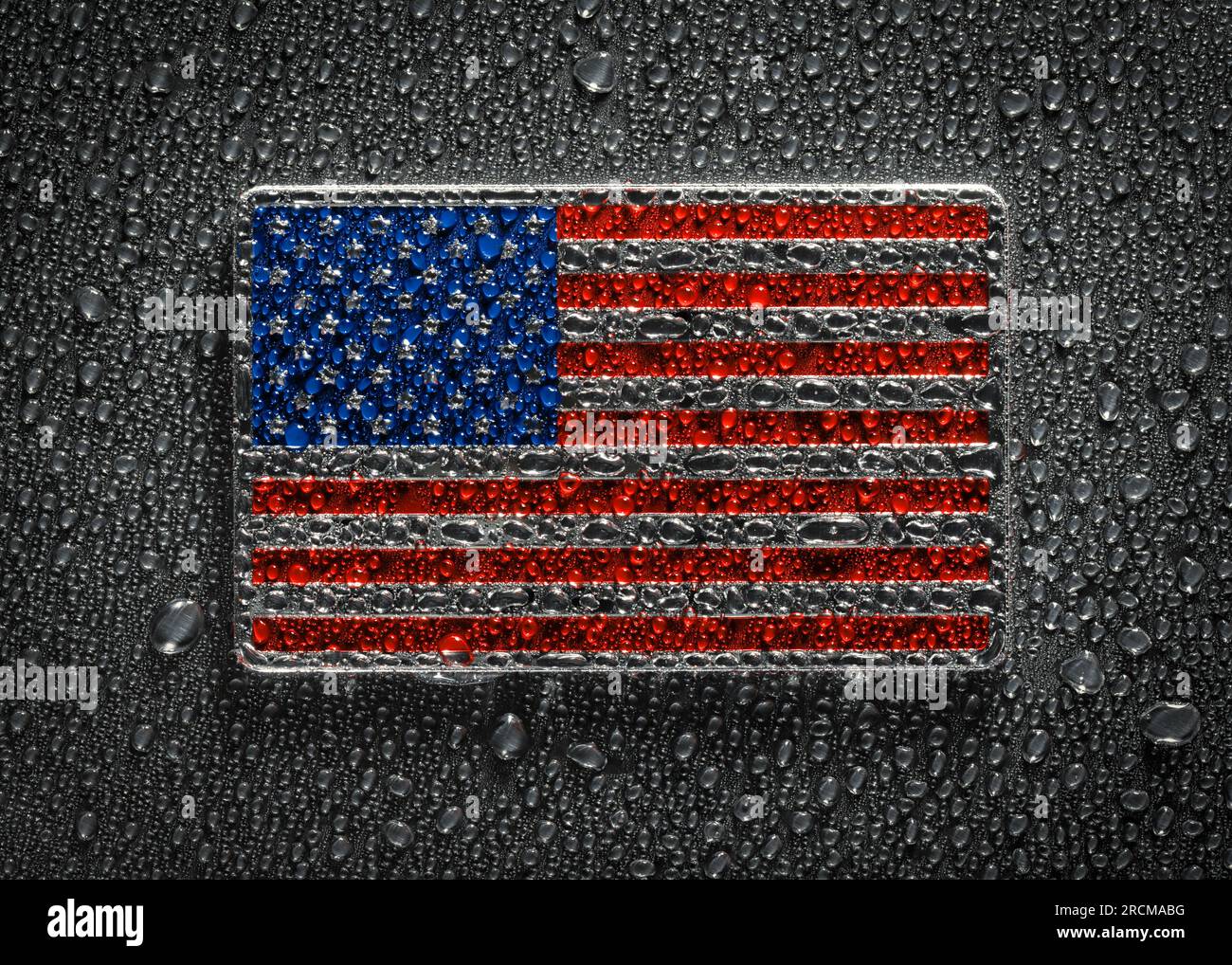 US-amerikanische Metallflagge mit Wassertropfen bedeckt. Die glänzende US-Flagge symbolisiert die Vereinigten Staaten von Amerika. Stockfoto