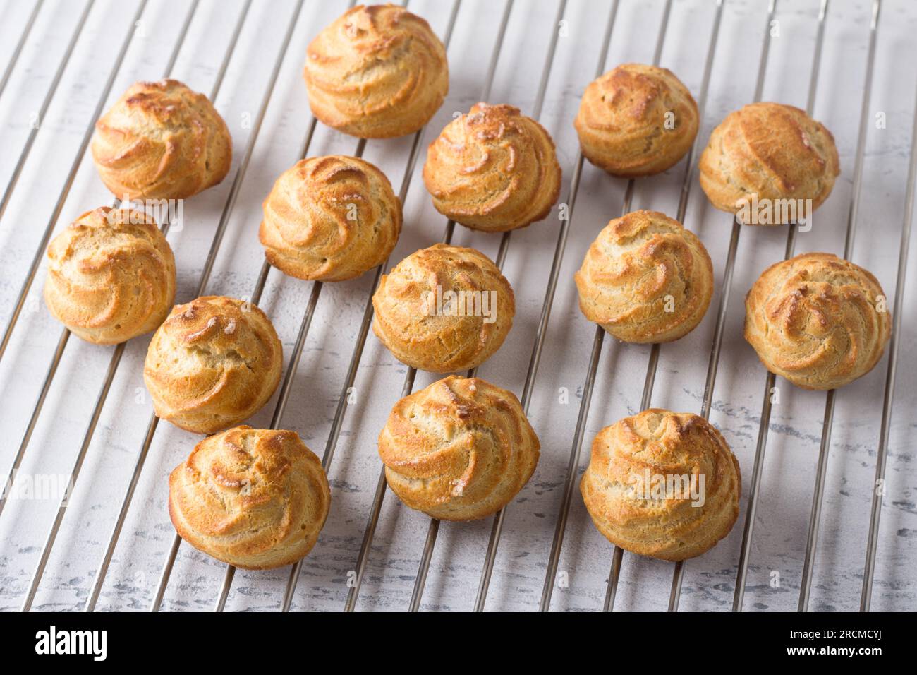 Frisch gebackene glutenfreie Haferflocken-Profiteroles auf einem Metallgitter. Stockfoto