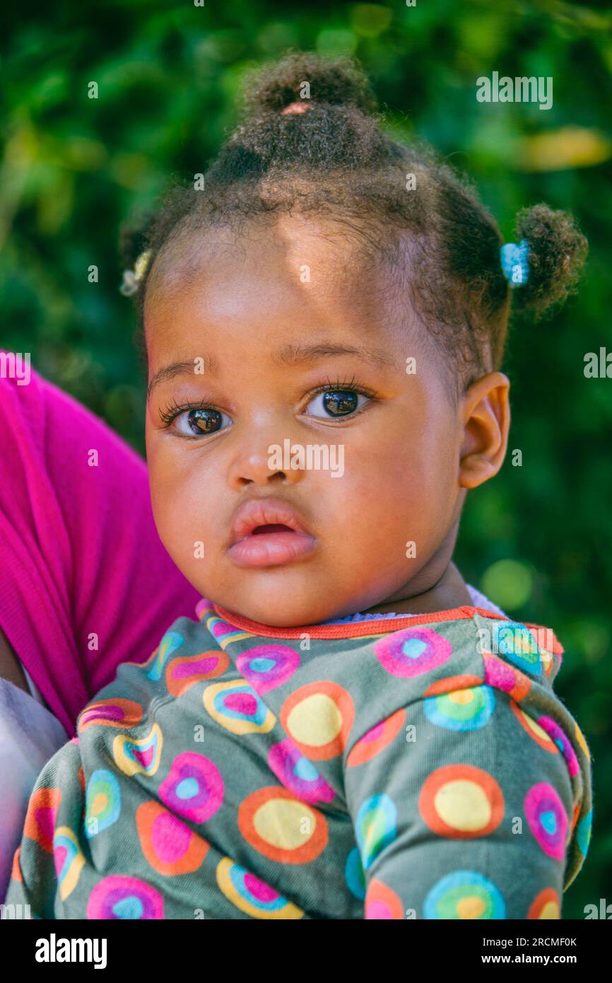 Porträt eines afrikanischen Babys im Freien mit Pferdeschwanz-Haarschnitt Stockfoto