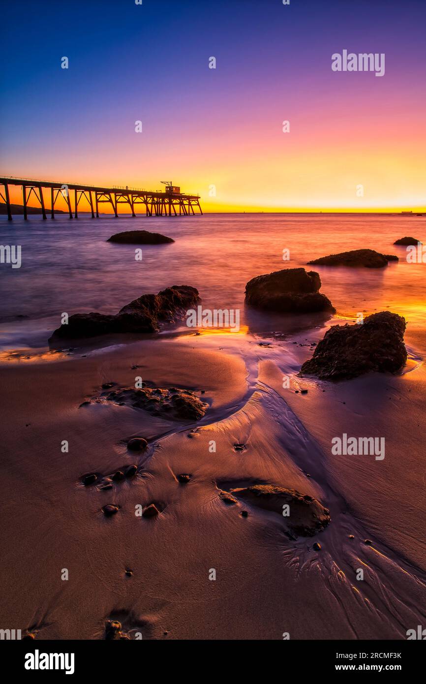 Malerische farbenfrohe Meereslandschaft bei Sonnenaufgang am Middle Camp Beach der Pazifikküste in Australien. Stockfoto