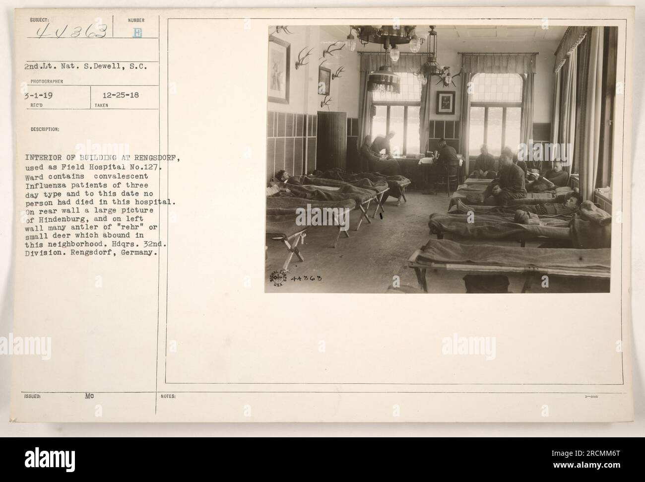 Das Innere des Gebäudes in Rengsdorf, Deutschland, wurde im Ersten Weltkrieg als Feldspital Nr.127 genutzt. Das Foto, aufgenommen am 25. Dezember 1918, zeigt die Station mit konvaleszenten Influenza-Patienten vom 3-Tage-Typ. Vor allem gab es bis zu diesem Zeitpunkt keine Todesfälle in diesem Krankenhaus. Die Rückwand zeigt ein großes Bild von Hindenburg, während die linke Wand mit mehreren Geweihen von kleinen Hirschen geschmückt ist, ein häufiger Anblick in der Gegend. Das Gebäude diente als Hauptquartier der 32. Division. Stockfoto Das Innere des Gebäudes in Rengsdorf, Deutschland, wurde im Ersten Weltkrieg als Feldspital Nr.127 genutzt. Das Foto, aufgenommen am 25. Dezember 1918, zeigt die Station mit konvaleszenten Influenza-Patienten vom 3-Tage-Typ. Vor allem gab es bis zu diesem Zeitpunkt keine Todesfälle in diesem Krankenhaus. Die Rückwand zeigt ein großes Bild von Hindenburg, während die linke Wand mit mehreren Geweihen von kleinen Hirschen geschmückt ist, ein häufiger Anblick in der Gegend. Das Gebäude diente als Hauptquartier der 32. Division. Stockfoto