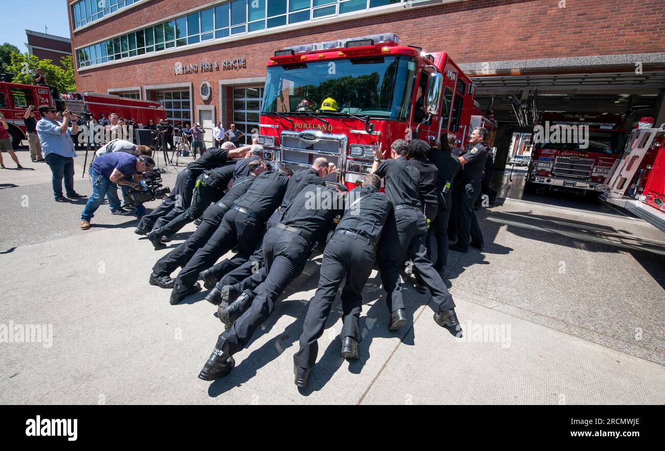 Die Feuerwehrleute von Portland Fire & Rescue führen die traditionelle „Push-in“-Zeremonie durch, während sie den neuen Elektromotor 1 am PF&R Staton 1 in Betrieb nehmen. Stockfoto