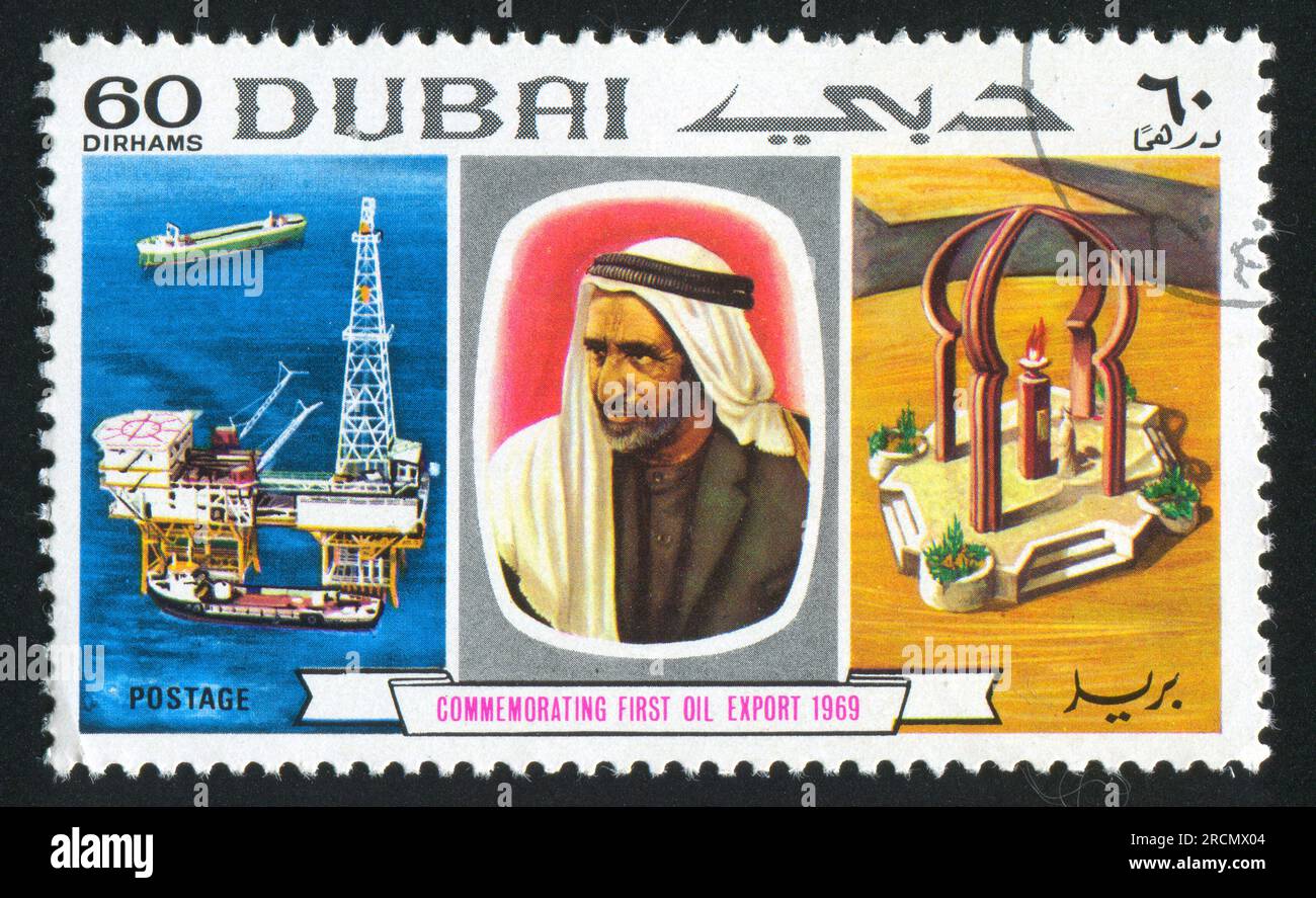 DUBAI - CA. 1983: Briefmarke gedruckt von Dubai, zeigt Ölstation, man und Denkmal, ca. 1983 Stockfoto