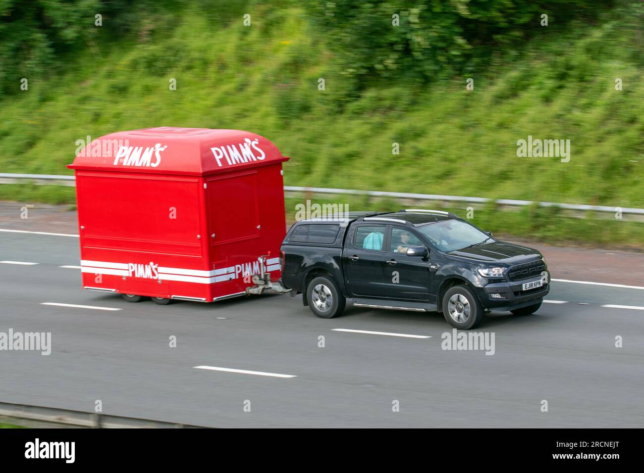 Red Pimm's Mobile Catering Bars, Vintage Bar Box Pimms Hire Food Truck Catering, Catering Buffet, Food Trucks; Fahrt mit hoher Geschwindigkeit auf der Autobahn M6 in Greater Manchester, Großbritannien Stockfoto