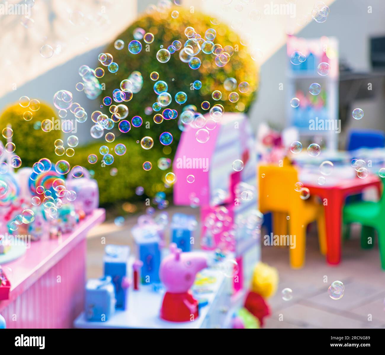 Kindergeburtstagsparty, Seifenblasen, die im Garten fliegen, viele Spielzeuge als Deko Stockfoto