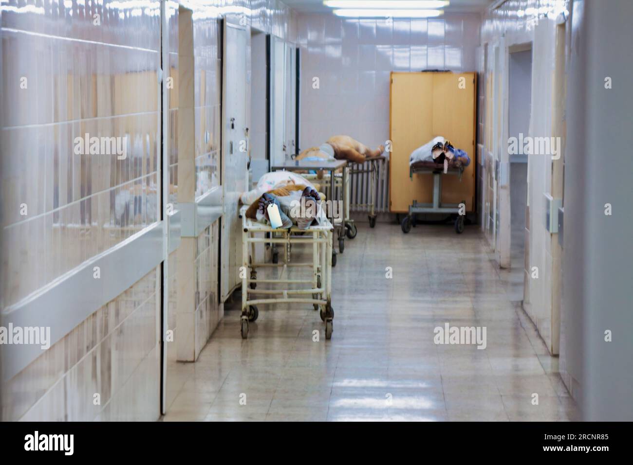 Leichenhalle im Krankenhaus mit mehreren Leichen, Etiketten an den Füßen hängen Stockfoto