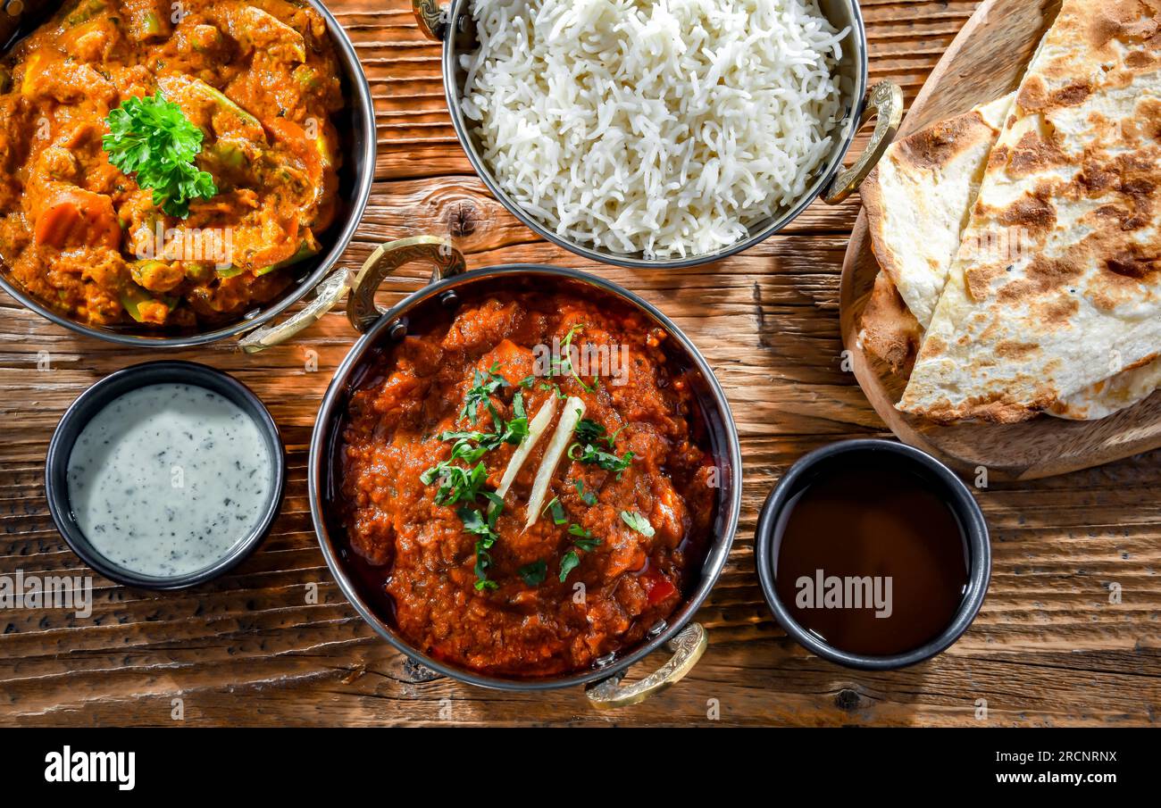 Heiße madras-Paneer und Gemüse-Masala mit Basmati-Reis, serviert in originalen indischen Karahi-Töpfen. Stockfoto