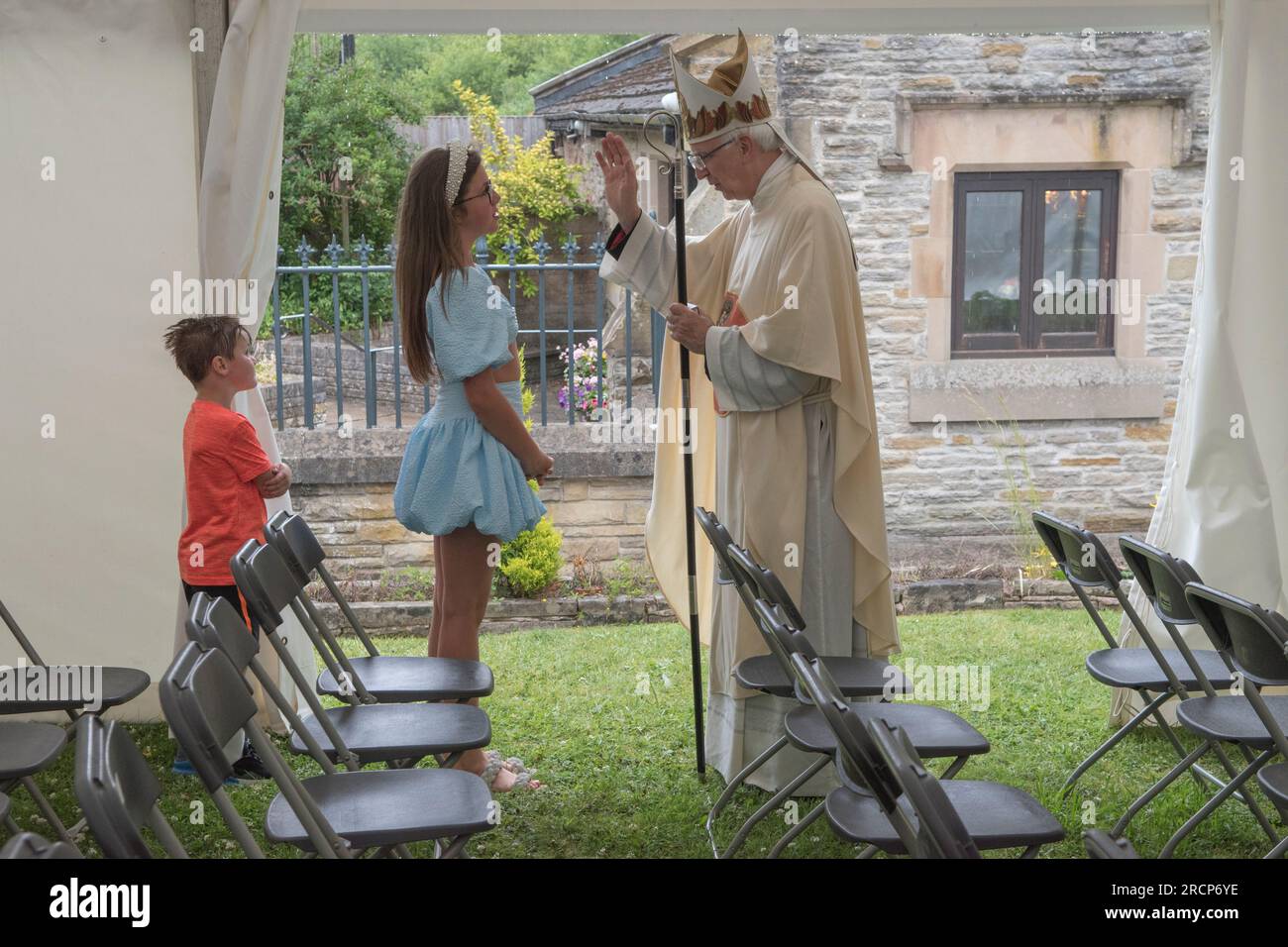 Katholischer Bischof von Wrexham UK. Der rechte Reverend Peter M. Brignall. Er segnet junge Katholiken, Kinder frommer katholischer irischer Reisender bei der Pilgerreise zum Heiligen Winefride-Festtag, nach einem Gottesdienst im Festzelt. Holywell, Flintshire, Wales, 25. Juni 2023. HOMER SYKES AUS DEN 2000ER JAHREN Stockfoto