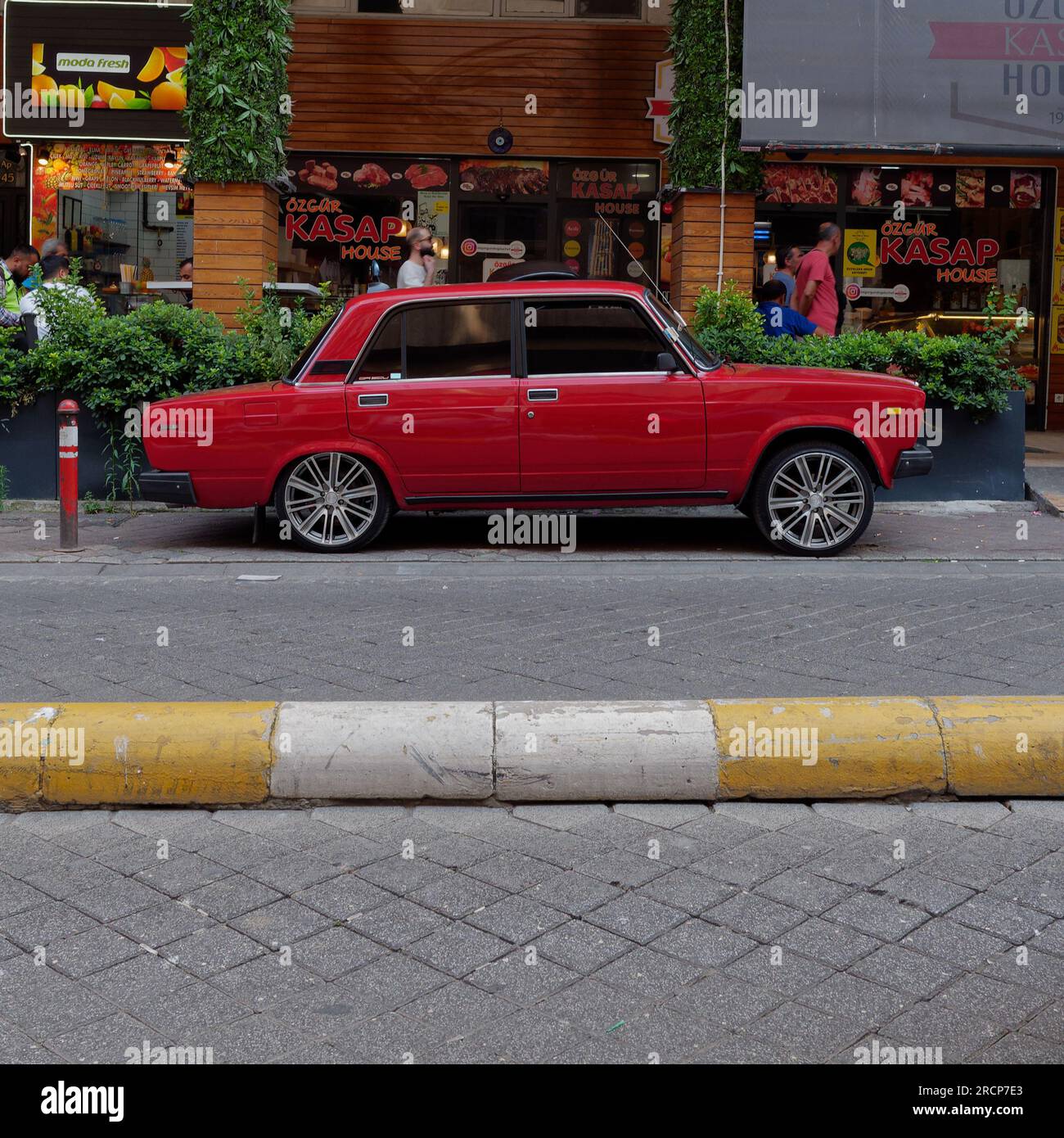 Dunkelrotes Retro-Auto mit getönten Fenstern auf einer Straße im Stadtteil Kadikoy auf der asiatischen Seite von Istanbul, Türkei Stockfoto